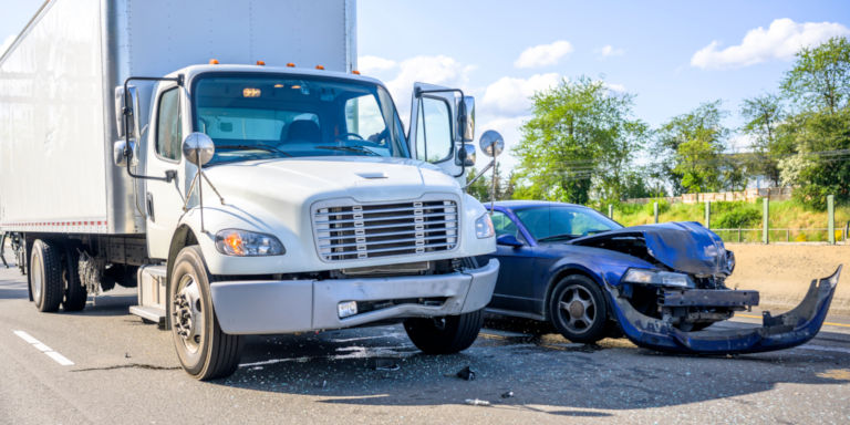 an auto accident involving a small car and a large box truck